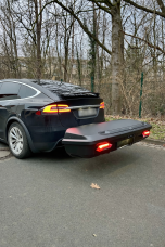 Thule Arcos XL "450l" Schwarzes Auto mit einer großen, flachen Anhängerkupplung hinten in der Natur.