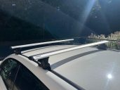 "Thule Fixpoint" Geeignet für Fahrzeuge mit Fixpunkt-System. Dachträger aus Aluminium auf einem Auto, mit Sonnenlichteinfall.