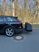 Thule Heckbox Onto Schwarzes SUV mit Gepäckträger auf der Rückseite, in der Nähe eines Baumes.