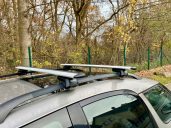 "Thule Raised Rail" - Geeignet für Fahrzeuge mit einer offenen Reling. Dachgepäckträger auf einem Auto, auf einem Parkplatz in der Natur.