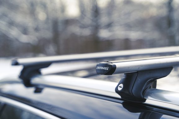 Dachgepäckträger aus Metall auf einem Auto vor einer verschneiten Landschaft.