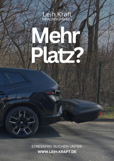 Schwarzes Auto mit Anhängerkupplung vor Bäumen, Text: „Mehr Platz?“
