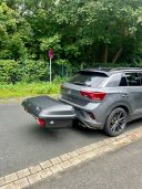 Thule Heckbox Arcos Gr. M Grauer SUV mit schwarzem Gepäckträger auf der Rückseite, Parkbereich an der Straße.