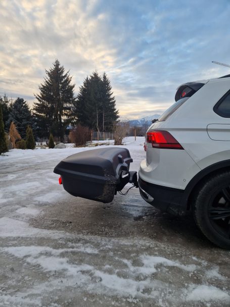 Thule Heckbox Arcos Gr. L Weißes SUV mit schwarzem Gepäckträger befestigt, Schnee und Bäume im Hintergrund.