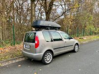 Thule Dachbox "Force XT Gr. M " Außenmaße: 175x82x45,5 cm Silberner Minivan mit Dachbox, an einer Straße im Wald geparkt. Herbstliche Umgebung.