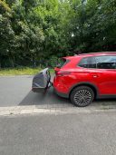 Thule Heckbox Onto Rotes SUV mit einem grauen Gepäckträger auf der Heckklappe.