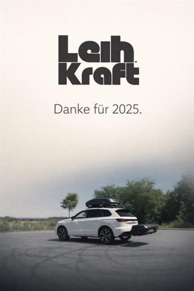 Weißes Auto mit Dachgepäckträger auf einer Straße, im Hintergrund ein bewölkter Himmel.