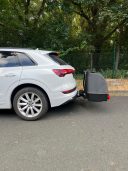 Thule Heckbox Onto Ein weißes SUV mit einem montierten Fahrradträger hinten.