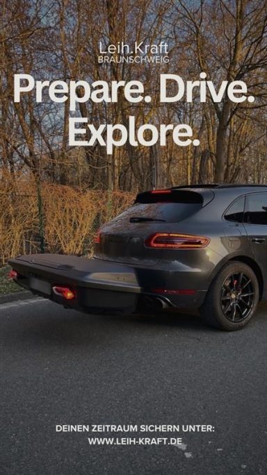 Schwarzes Auto auf einer Straße, umgeben von Bäumen, mit dem Text "Prepare. Drive. Explore."