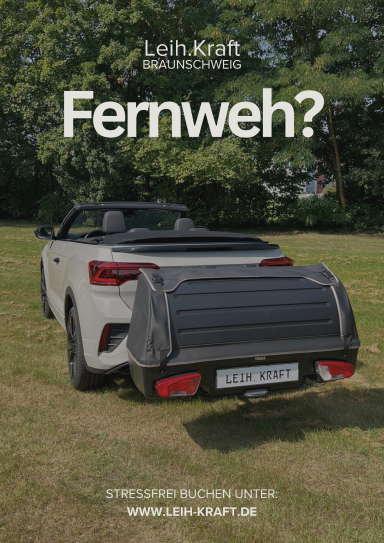 Ein weißes Cabrio mit einer Abdeckung im Hintergrund auf grünem Gras.